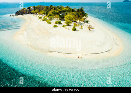 Giovane su una spiaggia tropicale con acqua blu e palme - Coron, Filippine Foto Stock