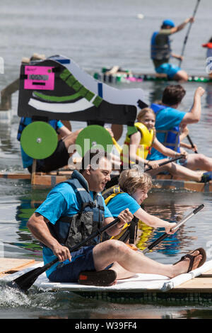 I partecipanti in gara nella categoria famiglia del Seafair cartone di latte Derby a Seattle, Washington, il 13 luglio 2019. La barca annuale gara è stato tenuto dal 1972 come parte di Seattle iconici Seafair celebrazione. I partecipanti hanno il compito di costruire una human powered natante con un minimo di 50 vuoto, uno-mezzo gallone di latte cartoni. Foto Stock