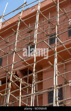 Impalcatura di bambù sulla casa, lavori di ristrutturazione. Ponteggio sulla costruzione, rosa parete e finestra. Sistema di ponteggio in costruzione. Jaipur, India Foto Stock