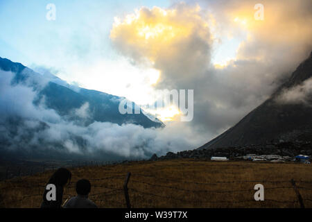 Il golden nuvole sopra la valle Kyanjin in serata. Foto Stock