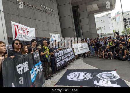 Hong Kong, Cina. 14 Luglio, 2019. Silent marzo a Hong Kong per fermare la violenza della polizia e di difendere la libertà di stampa vede lavorare premere, gli studenti di giornalismo e i loro educatori sia il passato e il presente si riuniscono per protestare. I manifestanti al di fuori della sede della polizia.La folla indossava tutto nero in segno di solidarietà. Credito: Jayne Russell/ZUMA filo/Alamy Live News Foto Stock