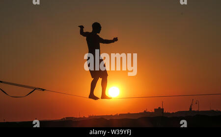 In equilibrio sulla fune al tramonto a Melbourne in Australia. Foto Stock