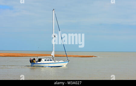 Yacht lasciando Felixstowe Ferry presso la foce del fiume Deben. Foto Stock