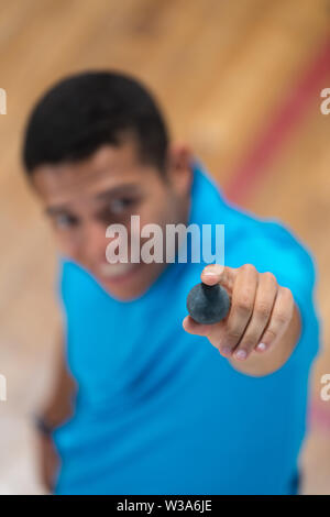 Uomo con una palla da squash a portata di mano Foto Stock