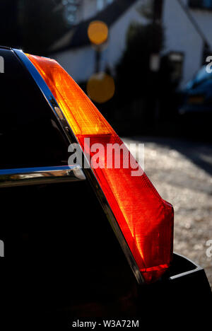 La luce del sole che splende attraverso la parte posteriore degli indicatori di direzione e luci di arresto su un BVM-GT auto sportiva Foto Stock
