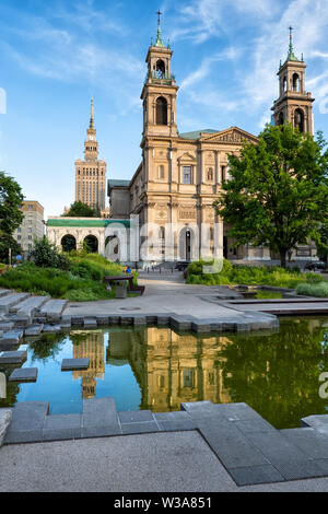 Grzybowski Square nel centro cittadino di Varsavia in Polonia, Chiesa di Tutti i Santi con la riflessione nella piccola piscina. Foto Stock