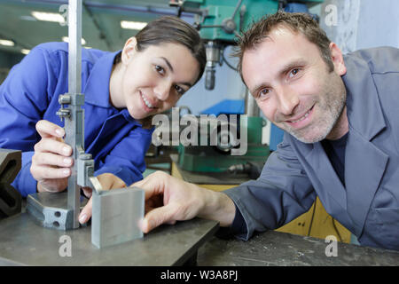 La donna come apprendista durante la lezione di falegnameria in officina Foto Stock