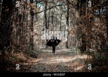 Daemon di Halloween con un coltello corre attraverso i boschi. Foto Stock