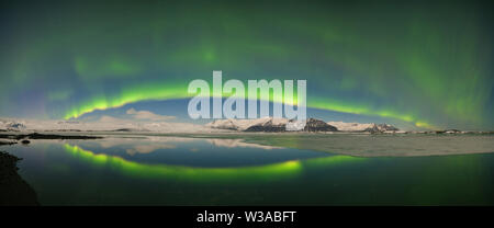 Aurora borealis sopra il mare. Jokulsarlon Glacier Lagoon, Islanda. Luci verdi a nord. Cielo stellato con luci polari. Paesaggio invernale notturno Foto Stock