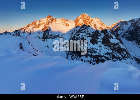 Monte Bianco di Courmayeur, Val Veny, e le piste da sci del comprensorio sciistico Courmayeur. Le Alpi innevate. Montagne innevate. Stazione sciistica in Valle d'Aosta Foto Stock