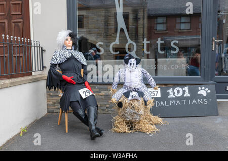 Una mostra a Garstang Spaventapasseri Festival. Cruella De Vil e un cane dalmata Foto Stock