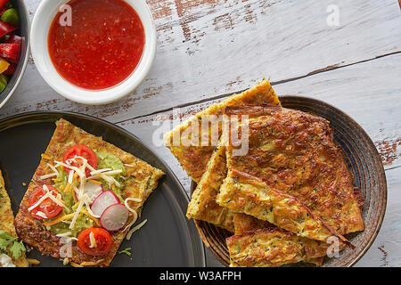 Frittelle di zucchini e parmigiano. Salmone affumicato, crema di formaggio, pomodori ciliegini e anelli di peperoni nana. Avocado, strisce di formaggio, insalata di patate Foto Stock