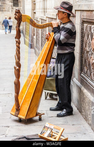 Barcellona, Spain-September 5° 2015: Busker suonare l'arpa al di fuori della cattedrale. Questo si trova nel quartiere Gotico Foto Stock