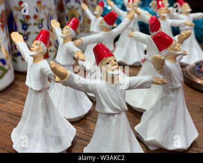 Figure di porcellana del Turco ballerini folk, un tradizionale "ufi whirling' danza con la mediazione. Bel regalo in un negozio di souvenir della Turchia Foto Stock