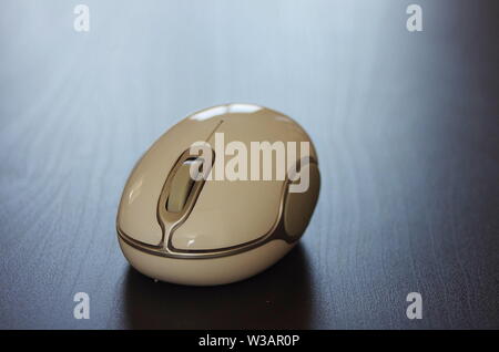 Un laptop wireless mouse su una scrivania nera in un ufficio. Foto Stock