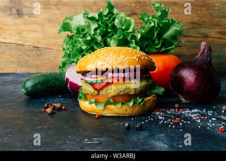Hamburger Vegetariano (fatta in casa hamburger) con ceci cotoletta e verdure fresche. Concetto di Veg. Copia dello spazio. Foto Stock