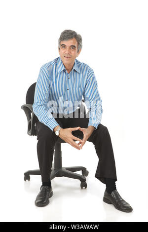 Imprenditore seduto in una sedia da ufficio Foto Stock