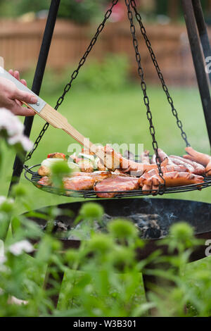 La cottura all'aperto su un altalena grill barbeque, Foto Stock