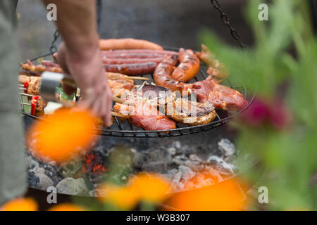 La cottura all'aperto su un altalena grill barbeque, Foto Stock