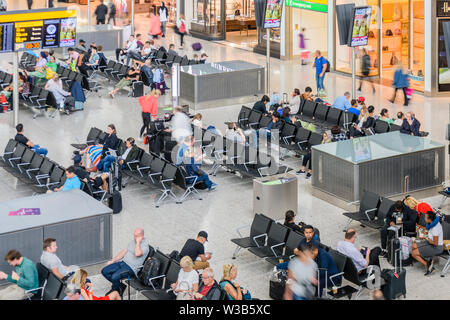 I passeggeri in attesa per i voli dal Terminal 3, l'aeroporto di Heathrow di Londra, Inghilterra, Regno Unito Regno Unito Foto Stock