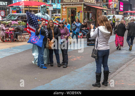 New York City, NY, Stati Uniti d'America - 16 Ottobre 2013: i turisti a piedi attorno a scattare foto e selfies nella zona di Times Square, Manhattan Foto Stock