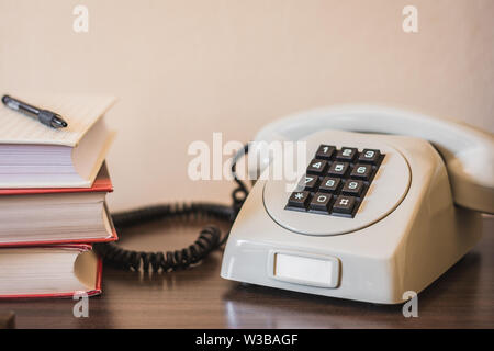 Vintage vecchio telefono con tasti neri e il ricevitore sul tavolo di legno. Uno stile rétro Foto Stock