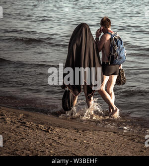 Un paio di turisti camminando sulla spiaggia Foto Stock