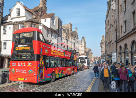 Open Top City sightseeing bus sul soleggiato High Street, con periodo di bella architettura e la gente che camminava sul marciapiedi. Edimburgo, Scozia, Regno Unito. Foto Stock