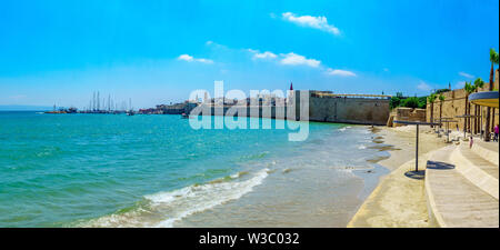 Acre, Israele - Luglio 08, 2019: vista panoramica della spiaggia di cavalli, mura sul mare e il porto di pesca, con la gente del posto e i turisti, nella città vecchia di Acri Foto Stock