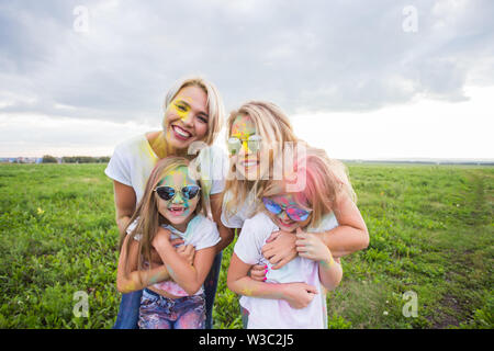 La famiglia, il festival di holi e concetto di vacanze - Ritratto di madri e figlie coperto di vernice Foto Stock