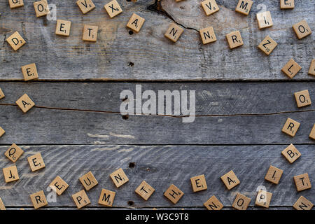 Piastrelle Scrabble ha creato un confine su un sfondo di legno Foto Stock