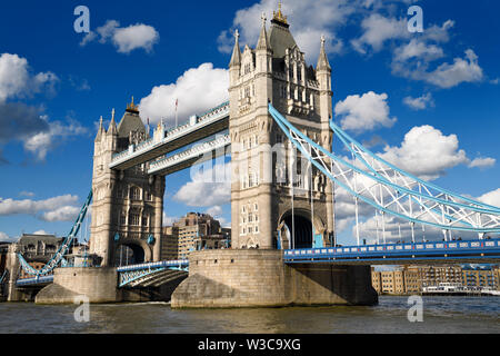 Twin torri in pietra della torre di Ponte sul Fiume Tamigi a Londra con il blu e il bianco del ponte di sospensione e elevati pedestrain camminamento e a bilico Foto Stock