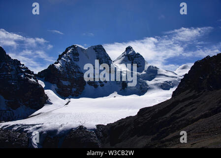 Pequeño Alpamayo (17618 piedi/5370 metri) e leader sul ghiacciaio fino a essa, Cordillera Real, Bolivia Foto Stock