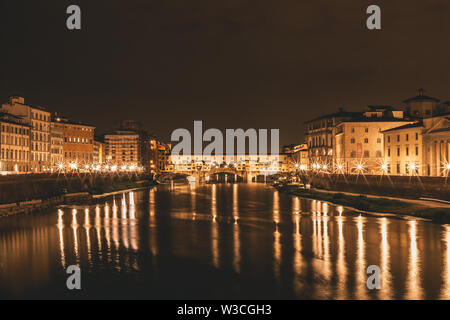 Ponte Vecchio e gli edifici nelle vicinanze di notte riflettendo sul fiume Arno. Firenze, Italia. Foto Stock