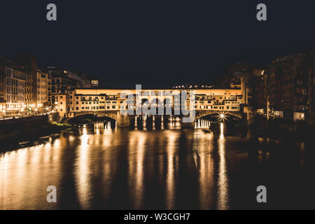 Ponte Vecchio e gli edifici nelle vicinanze di notte riflettendo sul fiume Arno. Firenze, Italia. Foto Stock