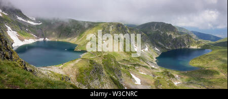 Un sacco di persone escursionismo, l'occhio e il lago di rene panorama sulla montagna Rila con singolo iceberg galleggiante sul lago glaciale di superficie e notevole velatura Foto Stock