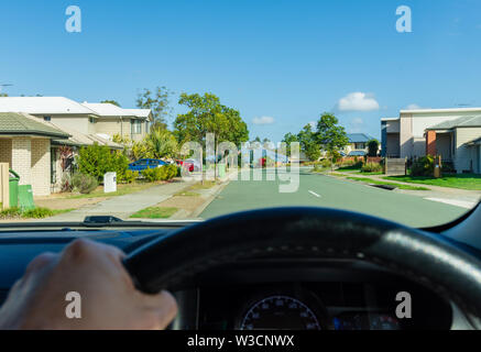 La vista di un guidatore di guidare una vettura attraverso i sobborghi di Australia Foto Stock