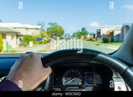 La vista di un guidatore di guidare una vettura attraverso i sobborghi di Australia Foto Stock