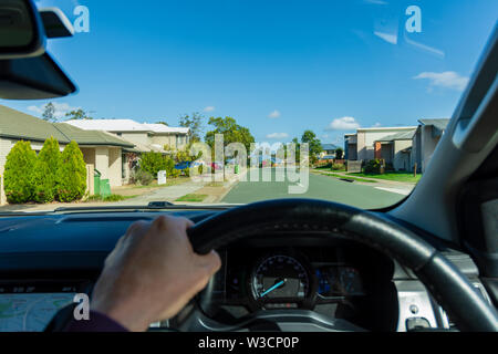 La vista di un guidatore di guidare una vettura attraverso i sobborghi di Australia Foto Stock