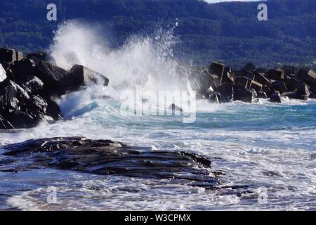 Onde che si infrangono sulle rocce Foto Stock