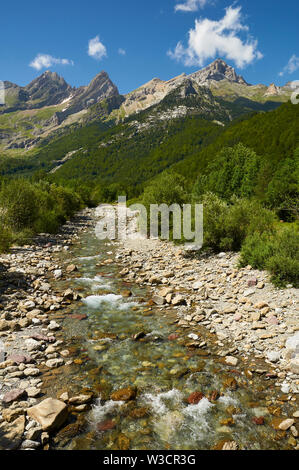 Fiume Cinca attraverso la Valle di Pineta con picchi in background nel Parco Nazionale di Ordesa y Monte Perdido (Sobrarbe, Huesca, Pirenei, Aragona, Spagna) Foto Stock