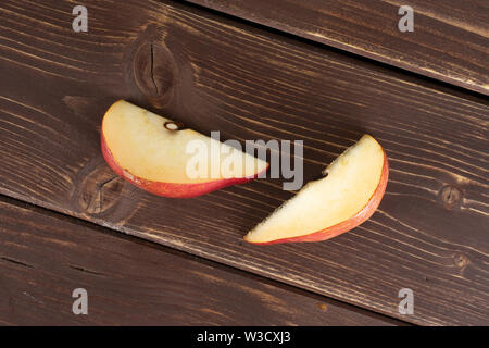 Gruppo di due fette di fresco rosso scuro pera anjou flatlay su legno marrone Foto Stock