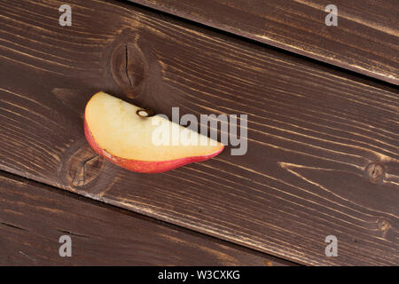 Una fetta di dolce rosso scuro pera anjou flatlay su legno marrone Foto Stock