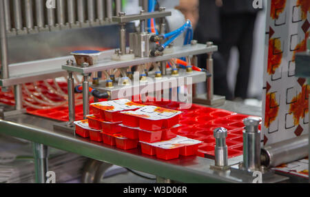 Processo di salsa automatico tazze di riempimento e sigillatura di macchina Foto Stock