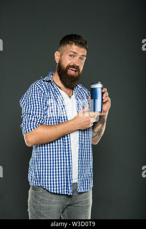 Le abitudini igieniche per gli uomini. Hipster holding gel o bottiglia di shampoo per igiene personale su sfondo grigio. Uomo Barbuto con prodotto per l'igiene. Igiene quotidiana e la salute. Foto Stock