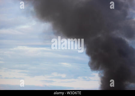 Camino di fabbrica fumatori, fumo nero del cielo. Foto Stock