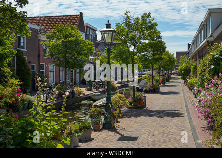 Leiden, Olanda - Luglio 05, 2019: Kijfgracht, piccolo canale nel centro storico cener di Leiden città decorata con fiori e piante Foto Stock