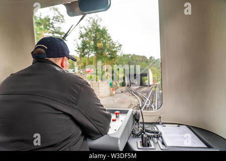 Driver del treno il funzionamento del servizio di diesel della Snowdon ferrovia di montagna lasciando Llanberis stazione ferroviaria per il vertice di Mount Snowdon, Snowdonia National Park, il Galles Foto Stock