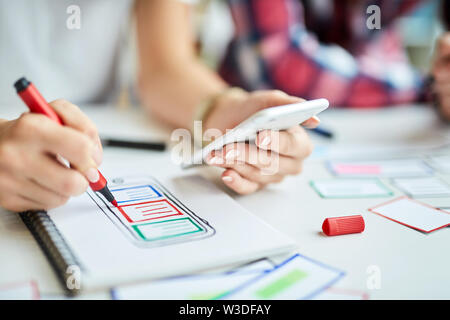 Primo piano di designer creando mobile app prototipo Foto Stock