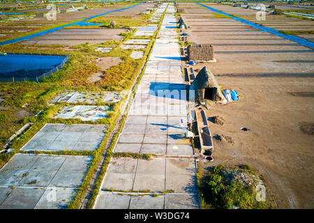 Allevatore locale a lavorare sui campi di sale in Bach Long, Giao Thuy, Namdinh provincia. Questa località è famosa per la produzione di sale nel nord del Vietnam. Foto Stock